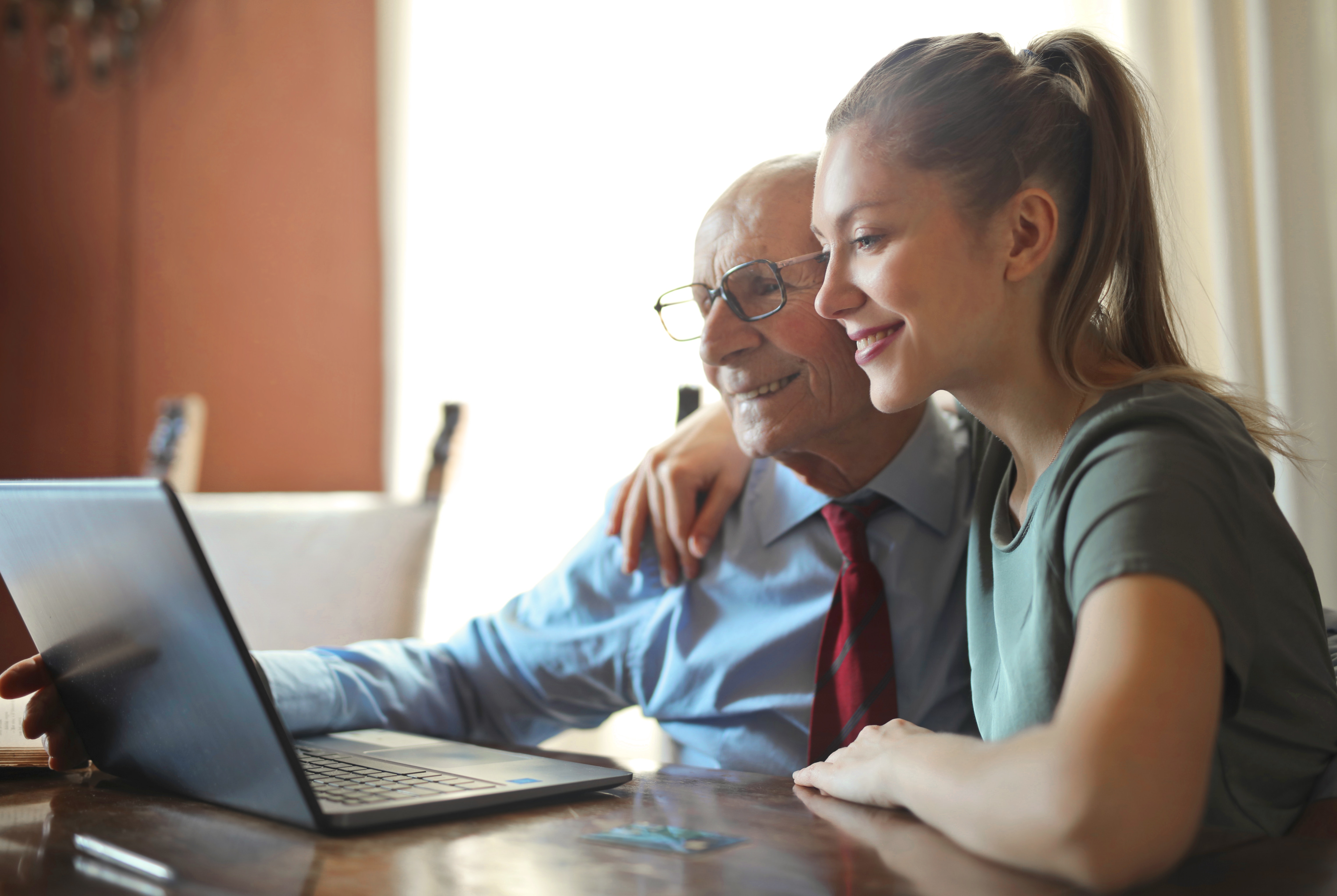 woman and elderly man in front of laptop