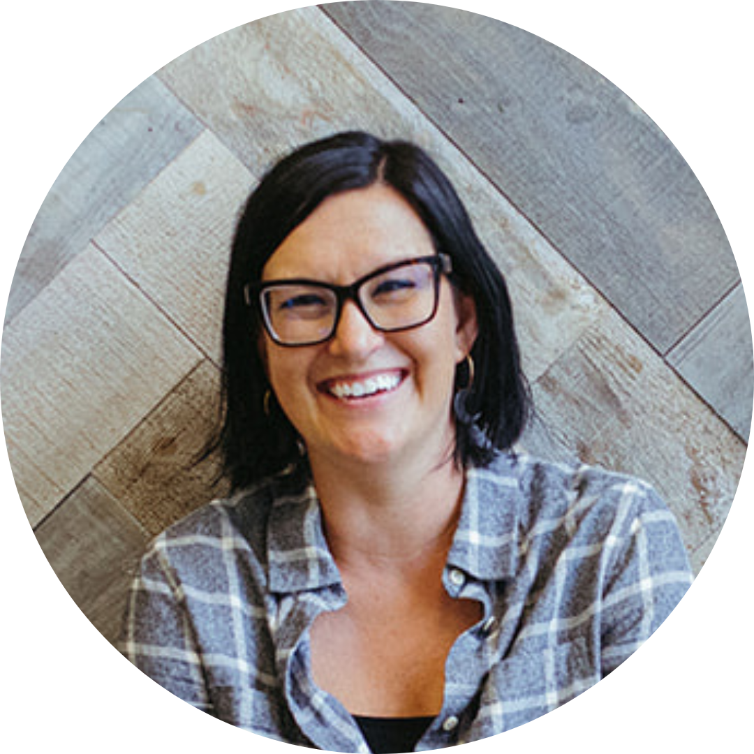 A photo of Melissa wearing a plaid buttondown shift smiling at the camera