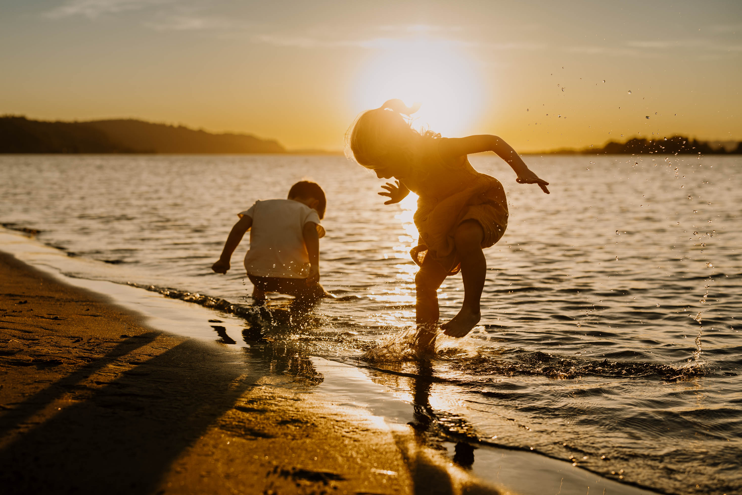 two kids splashing in the water and being playful