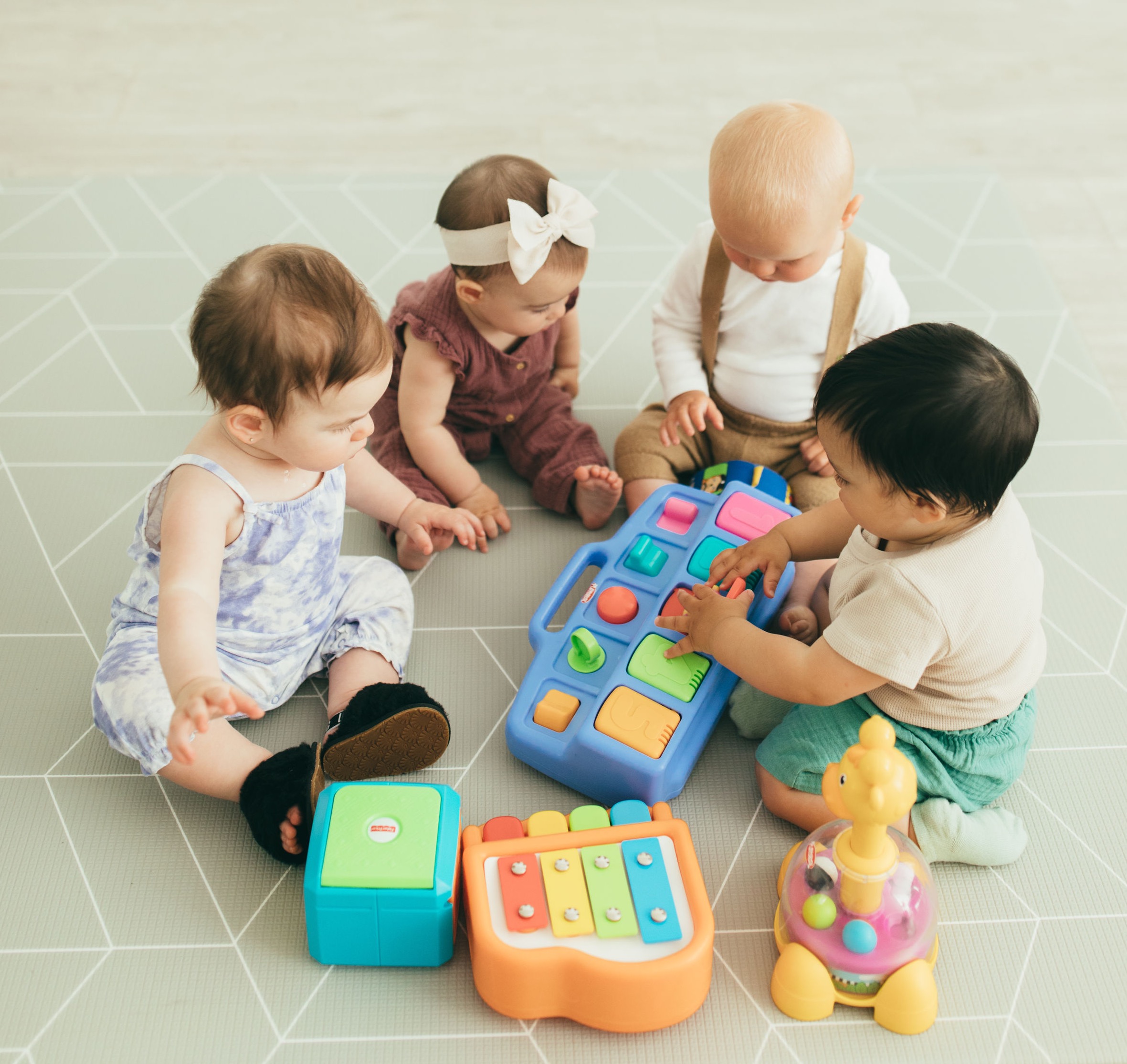Four Babies are playing with a cause-effect pop-up toy