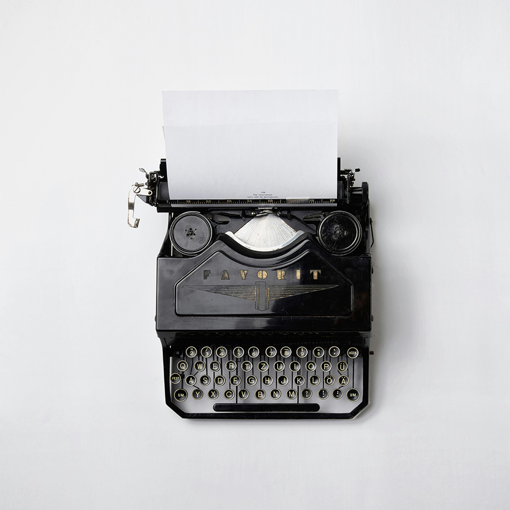 A typewriter on a white desk