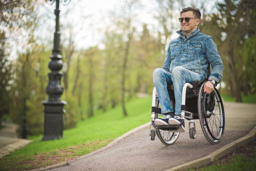 Hombre usando silla de ruedas y rodando por la ciudad