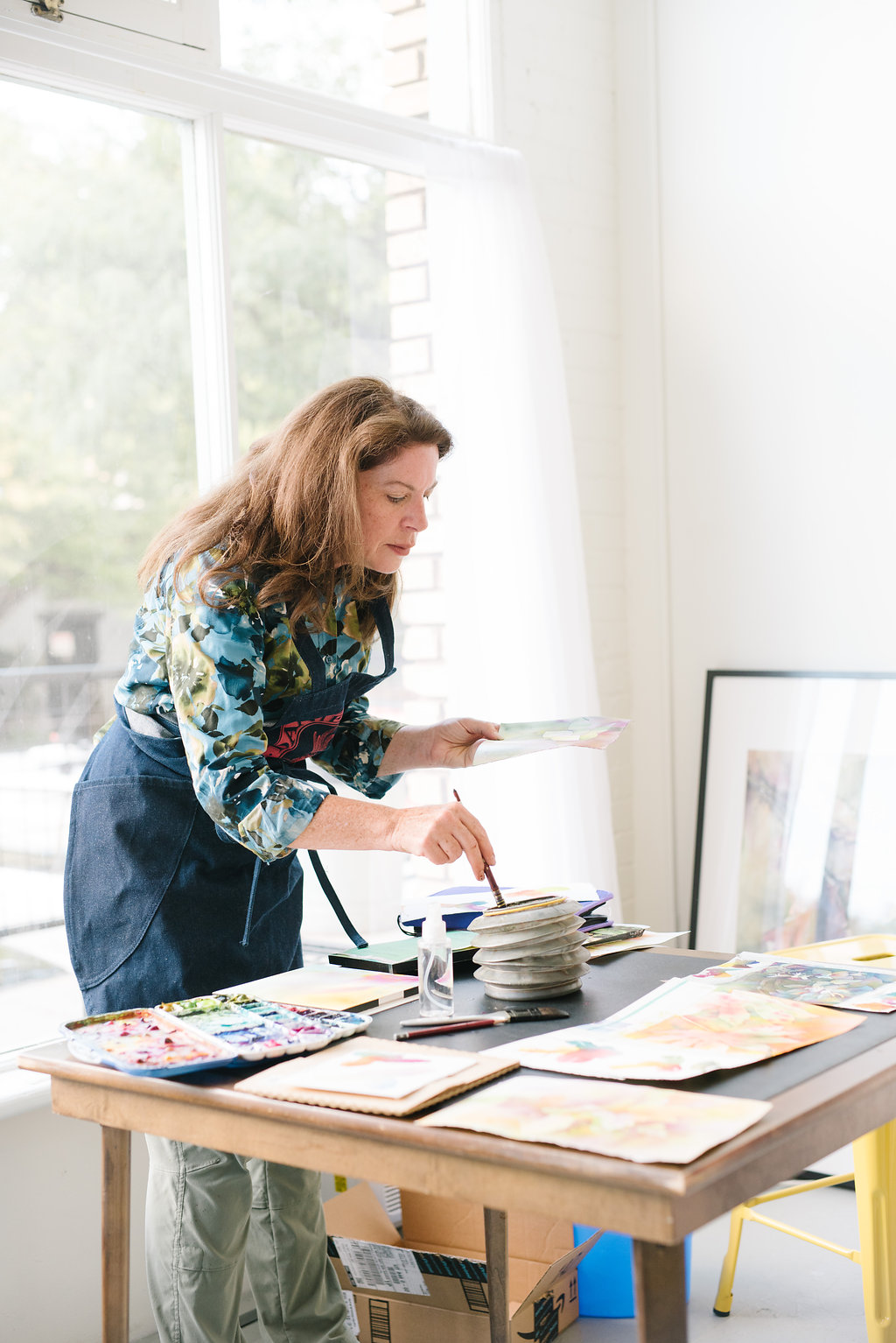 Artist Jana Parkin painting in front of a class.