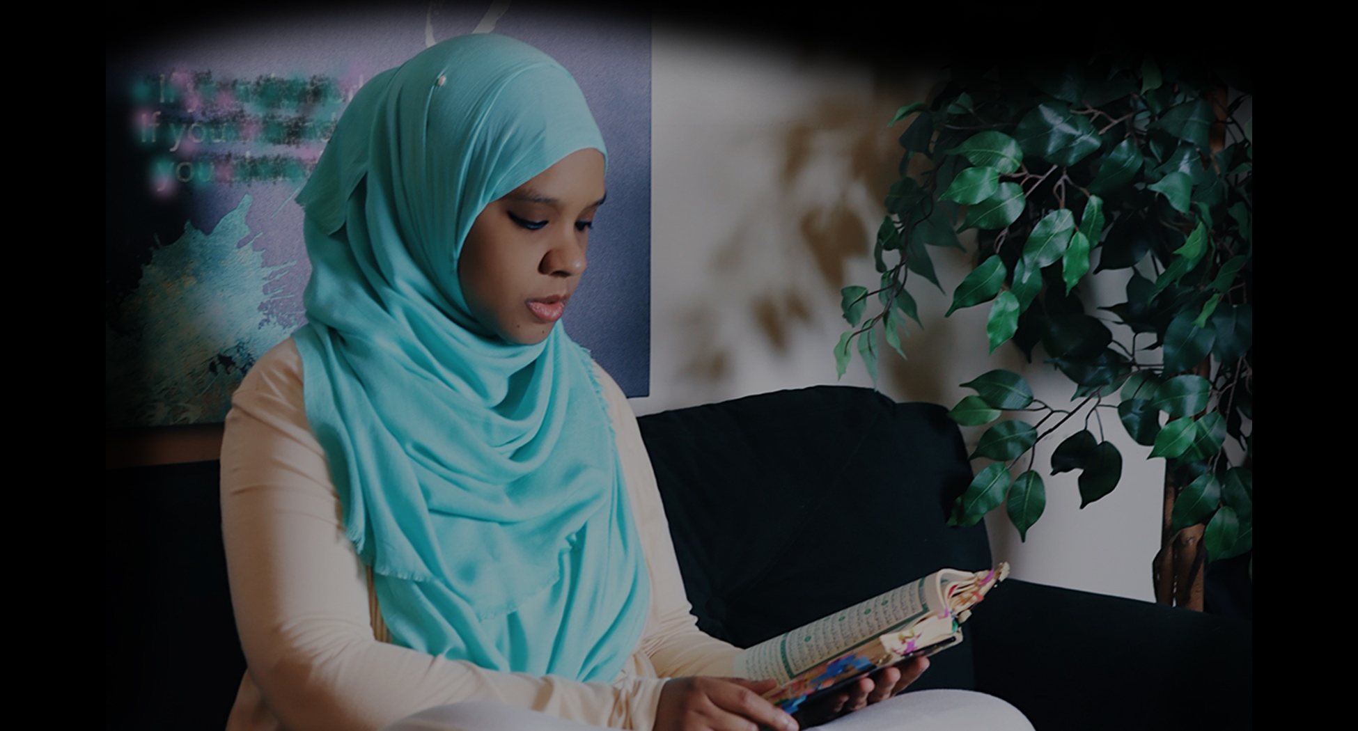 Photo of Umm Zakiyyah in turquoise hijab reading Qur