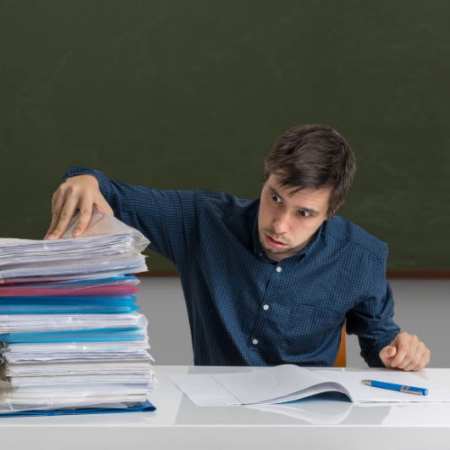 teacher looking horrified at pile of books