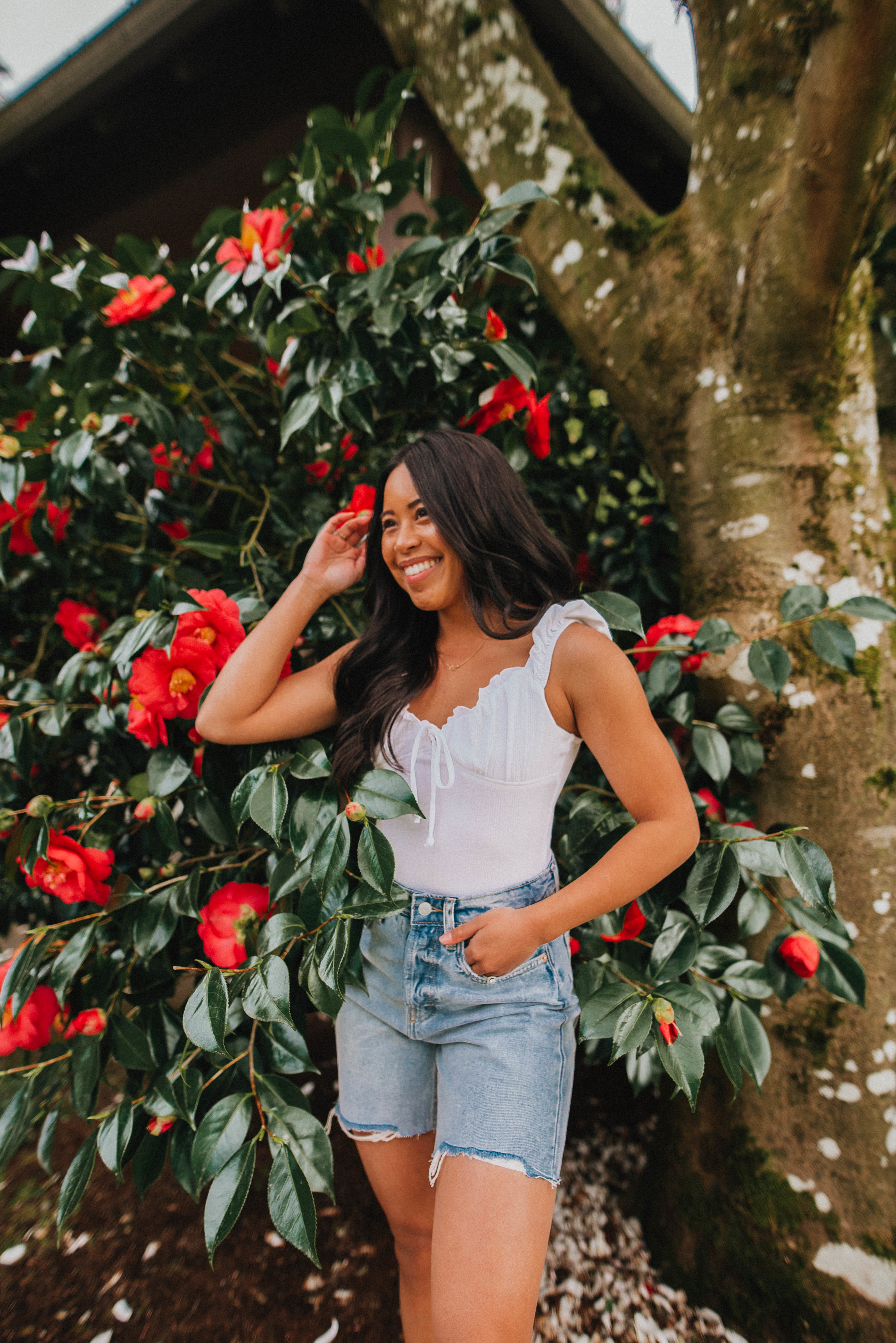 Emma Cortes - standing in front of flower bush 