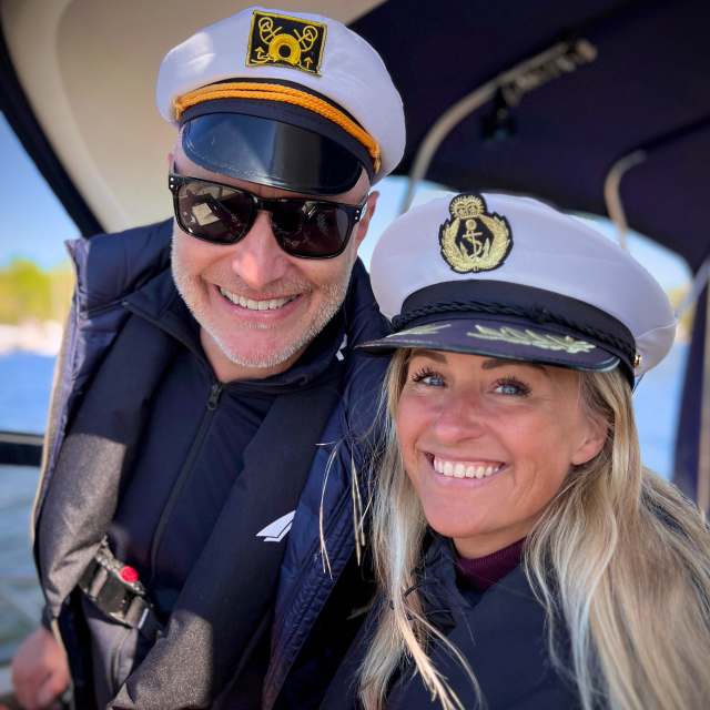 Couple male and female boat captains onboard a motor boat