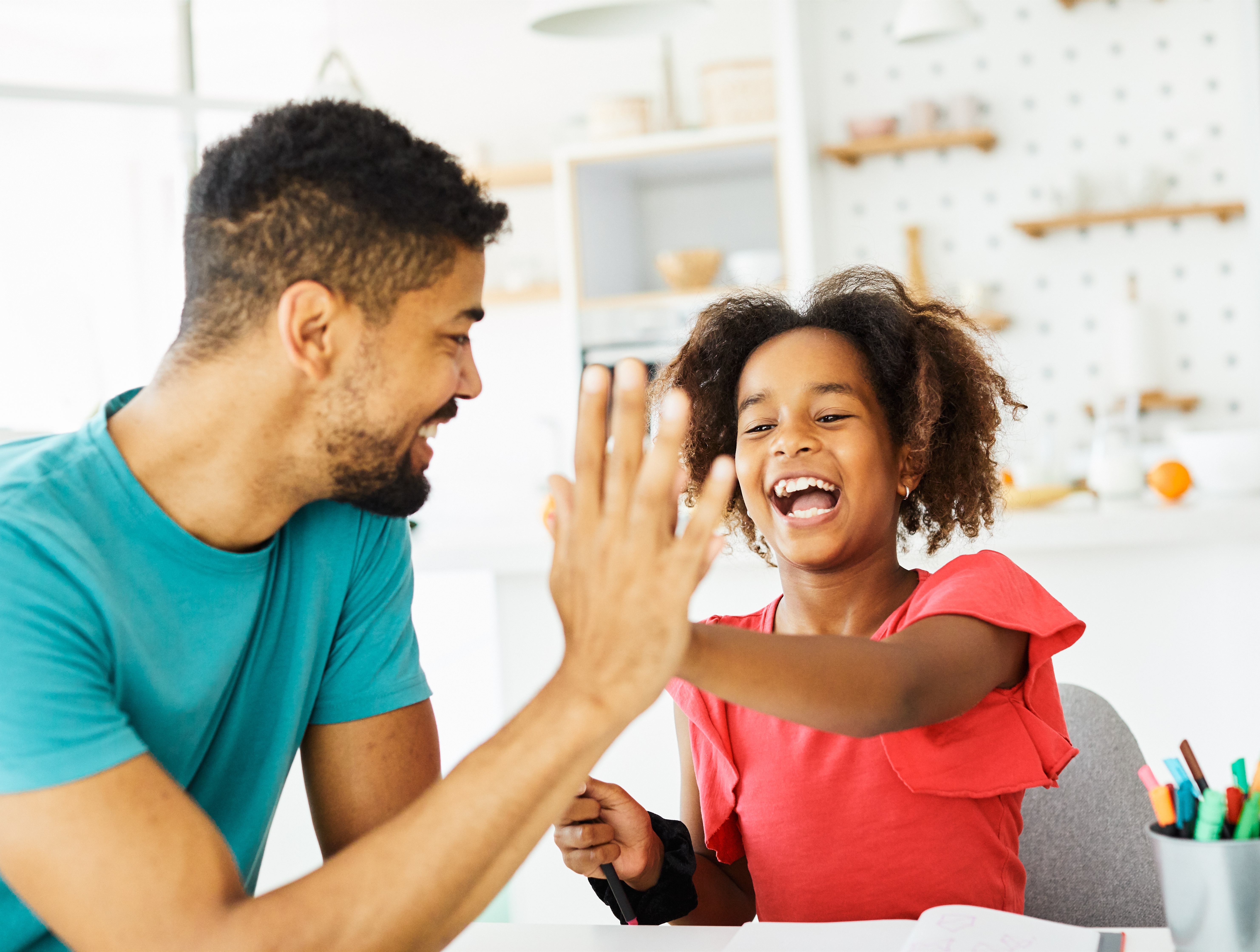 child and adult doing a high five