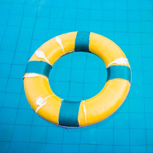 Blue and yellow life preserver floating in a pool