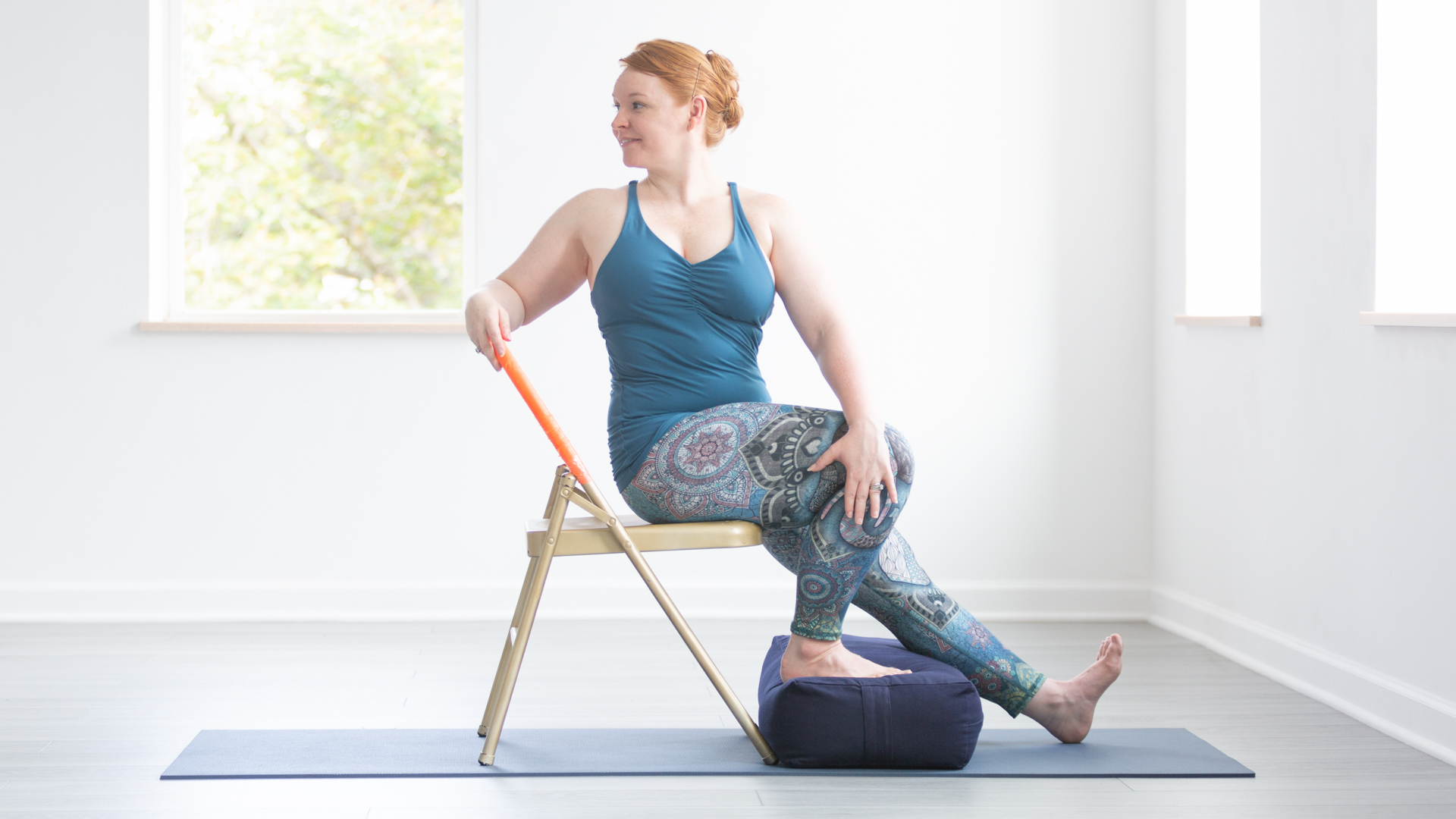 Woman seated on chair with one leg bent