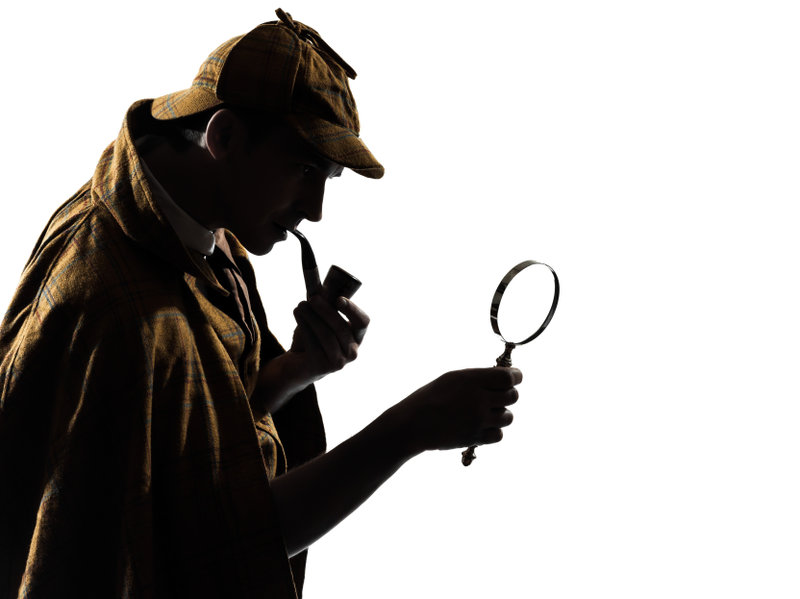 Sherlock Holmes looking through a magnifying glass