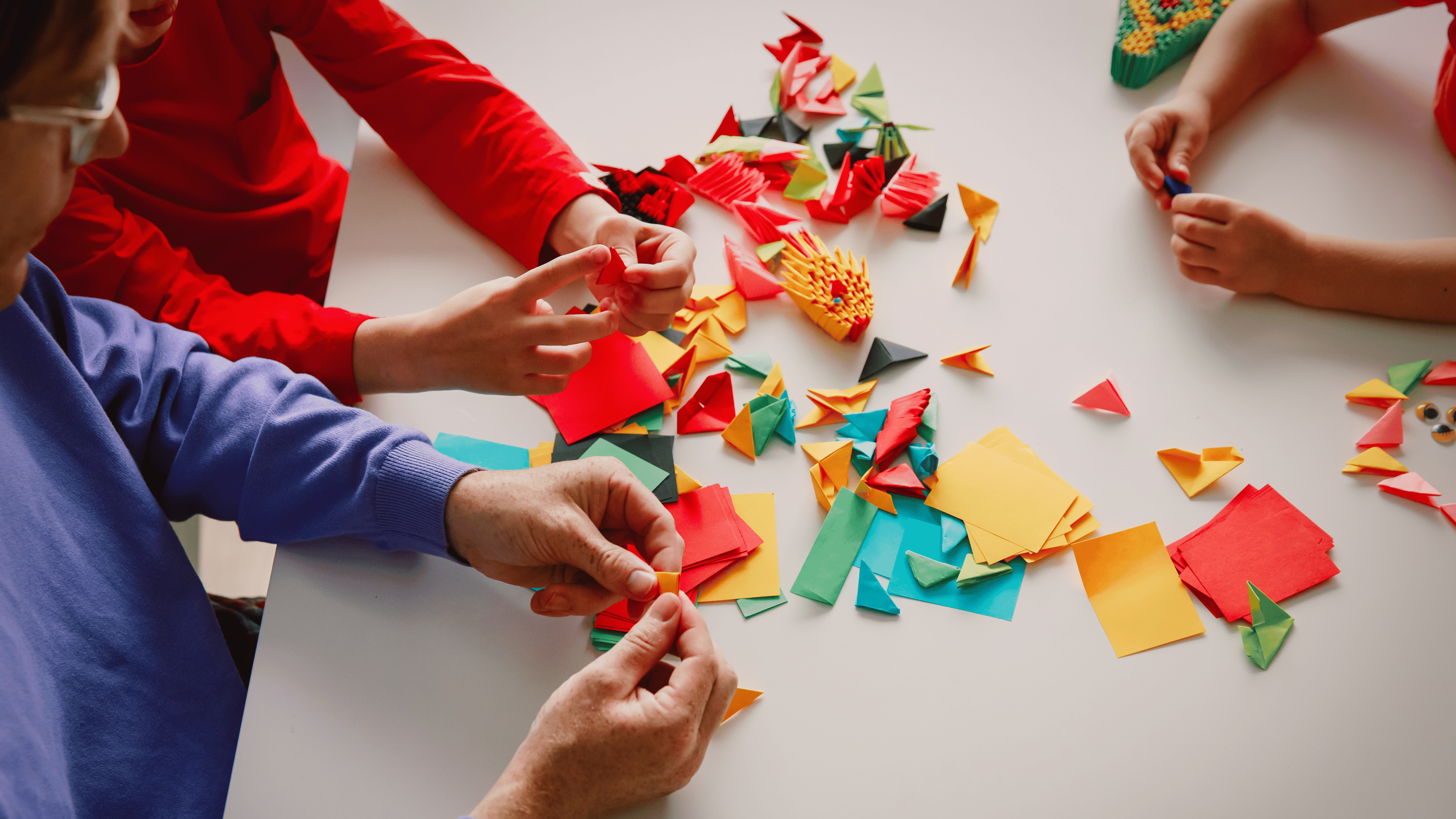 hands of people using paper making art