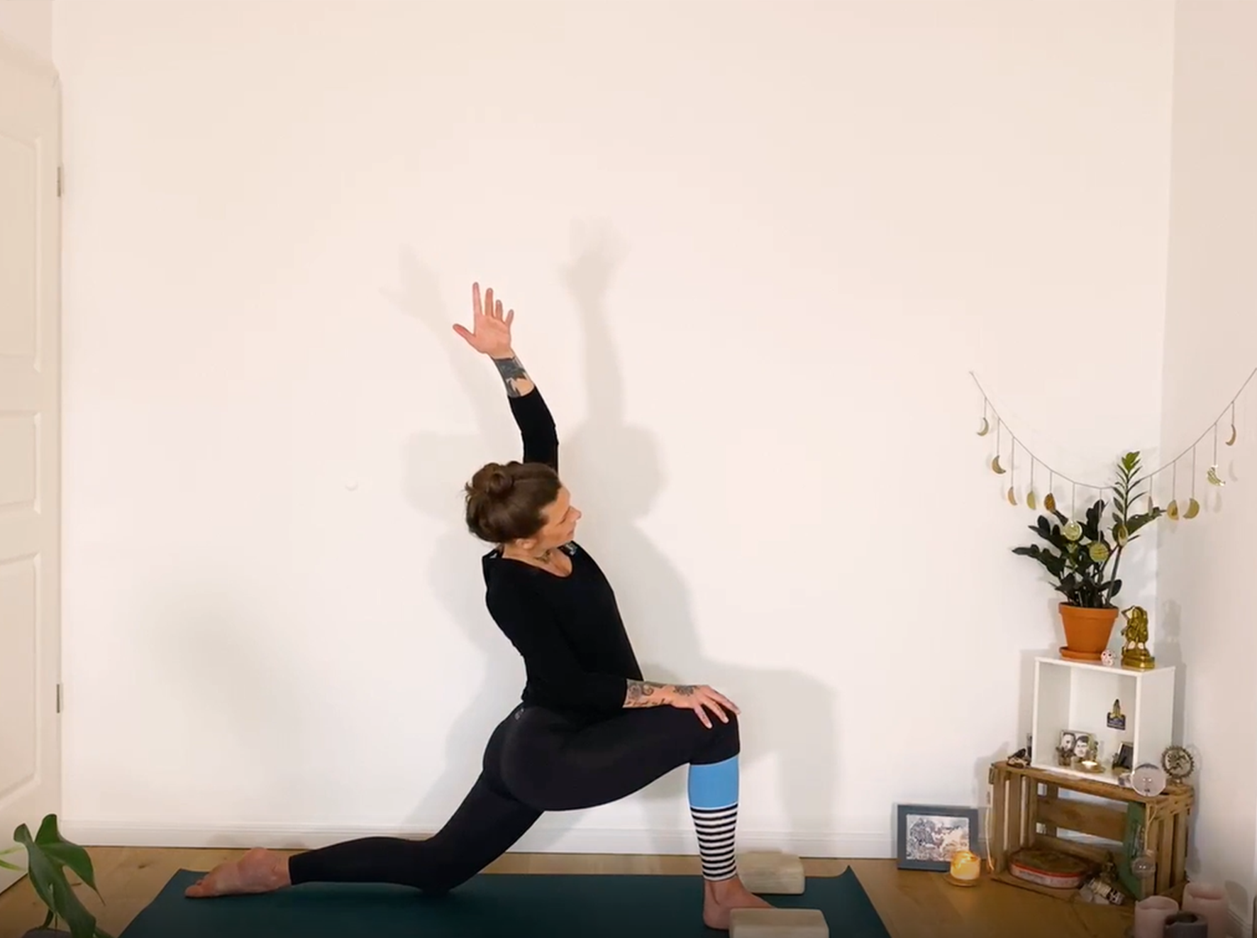 A person demonstrating a modified Anjaneyasana pose (lunge)