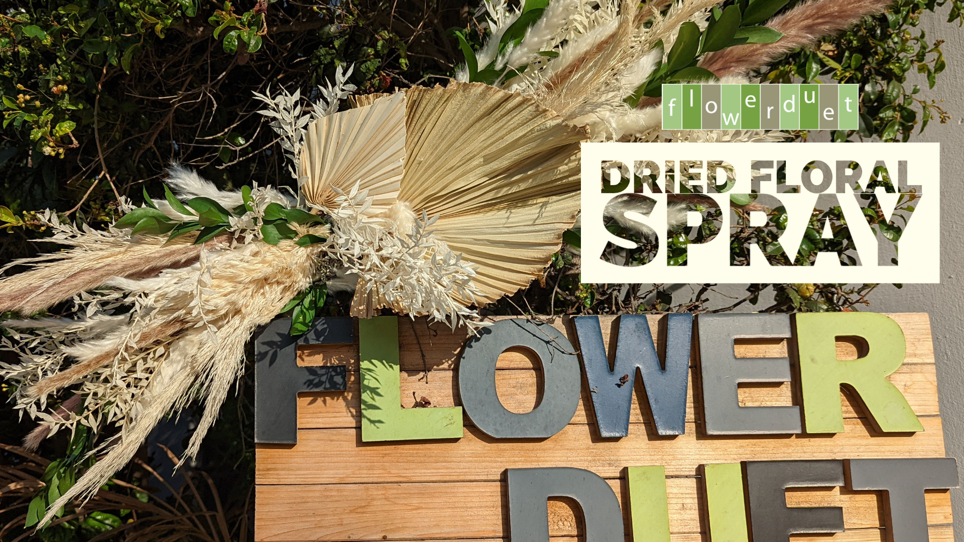 Dried floral spray on a sign that says flower duet