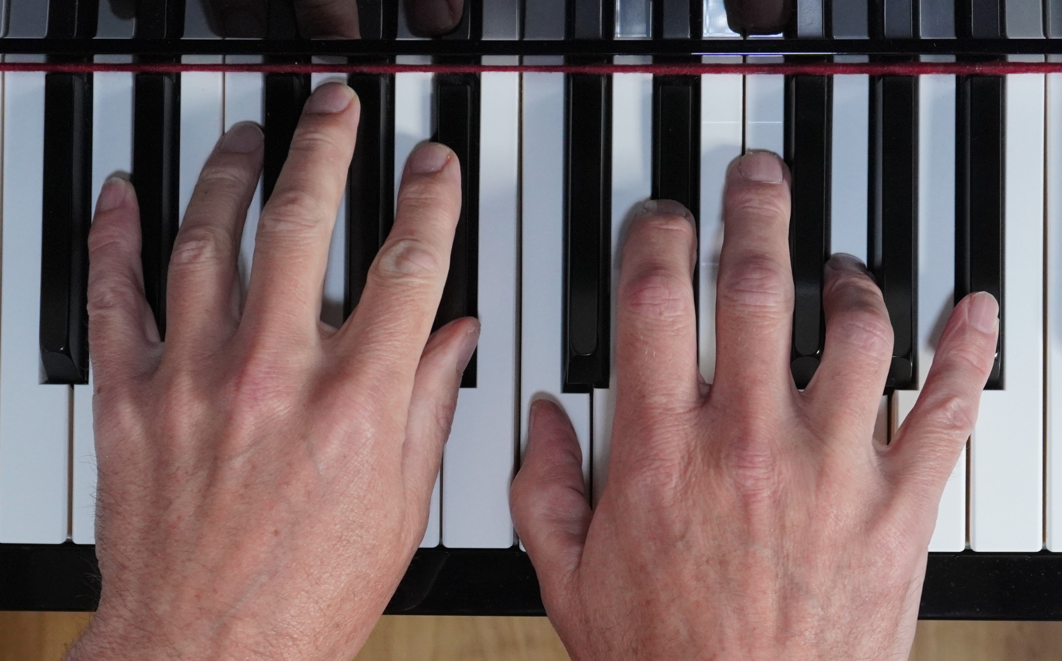 Julian Lamberts hands resting on a piano keyboard