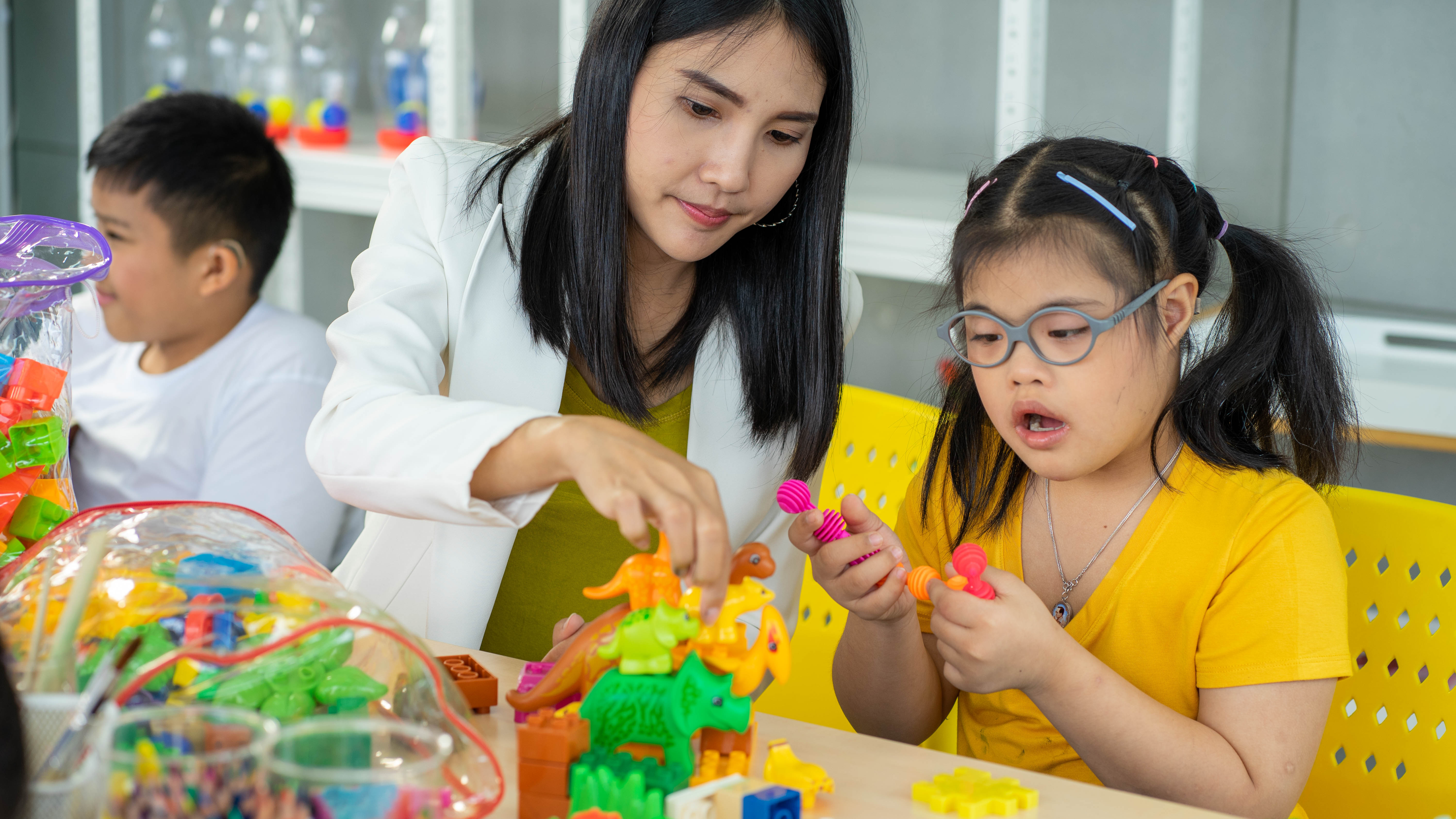 teacher helping students with manipulatives