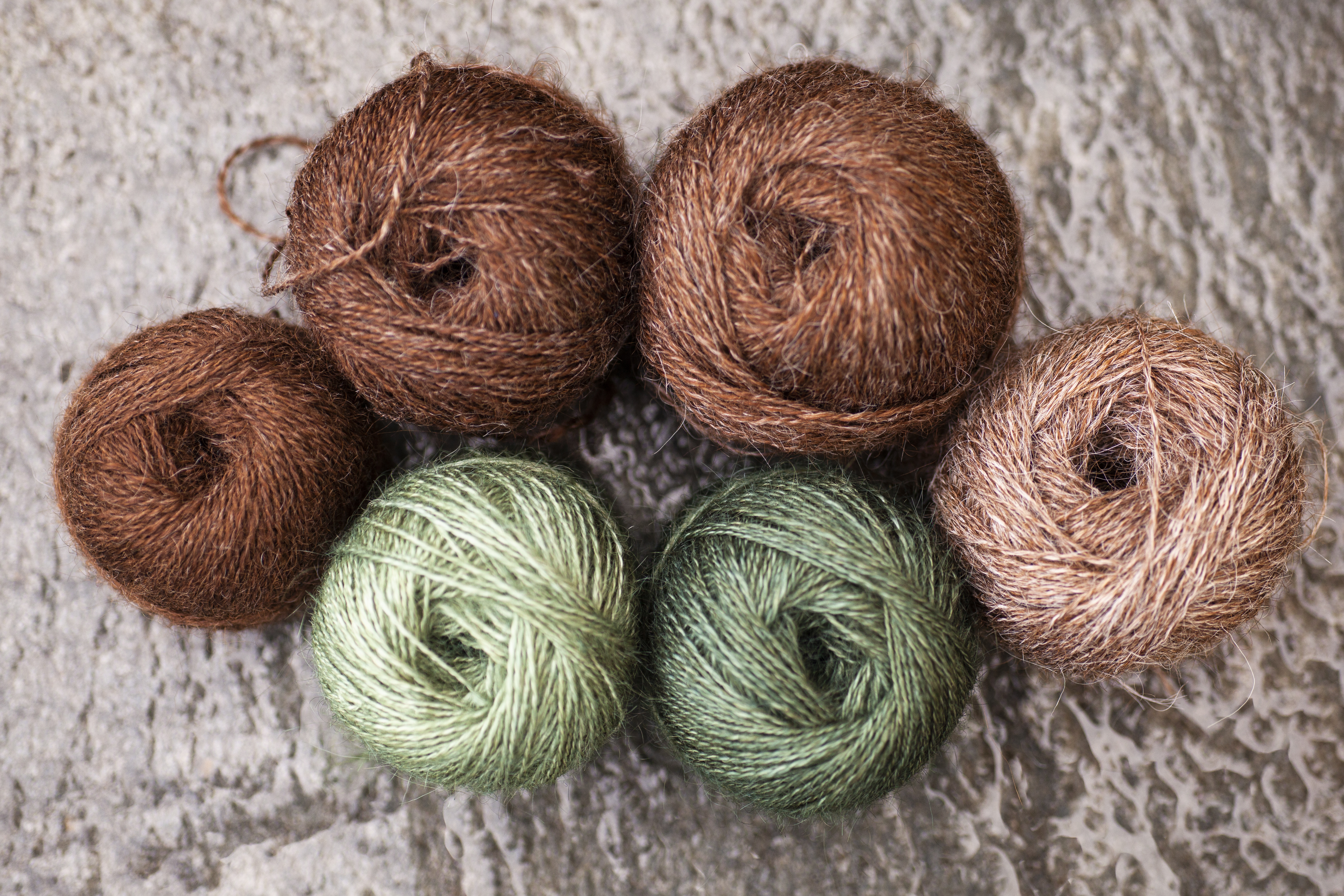 Balls of yarn in greens and natural browns. Photo by Dan Waltin