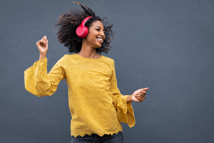 Dancer wearing yellow top and hot pink headphones