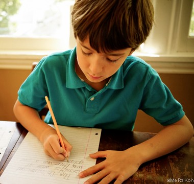 A young boy doing homework.