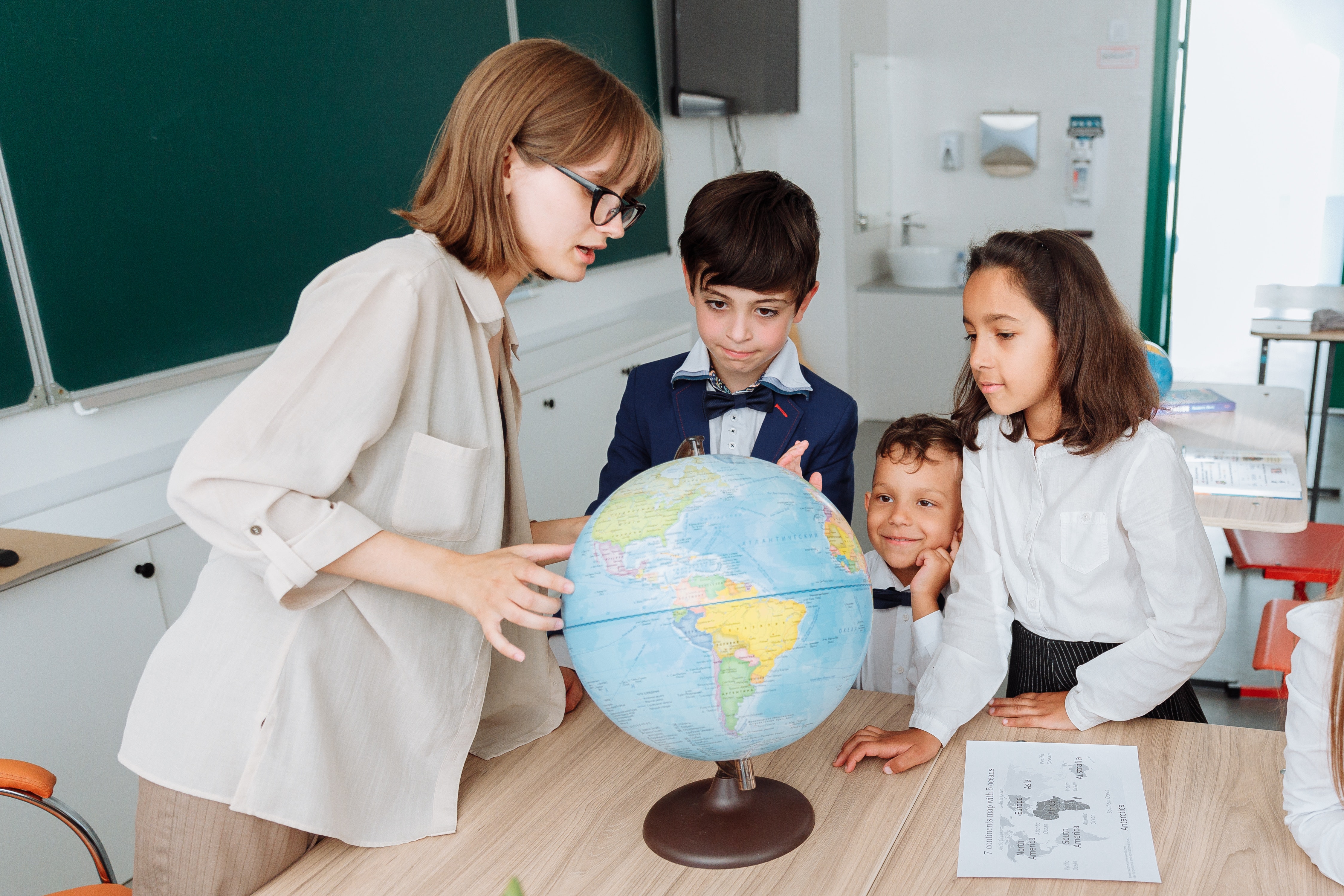 teacher showing students the globe