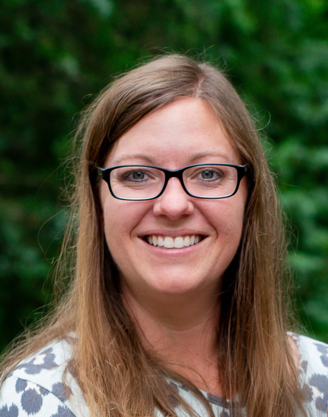 woman with glasses outside smiling