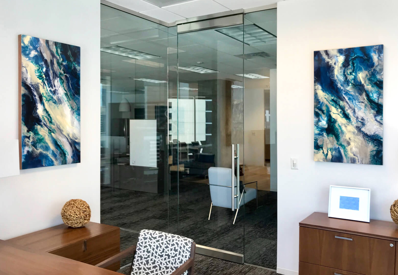 High-end office space in downtown Dallas featuring two of Anja Yamaji’s resin art paintings displayed on the wall, demonstrating the sophisticated resin art techniques taught in her resin art workshop.