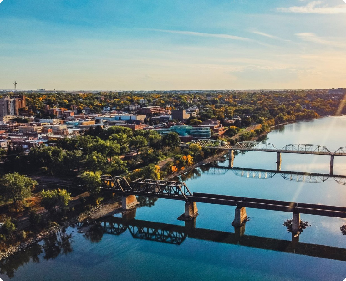 Aerial photograph of Medicine Hat, Alberta showing the city and two bridges that cross a body of water.