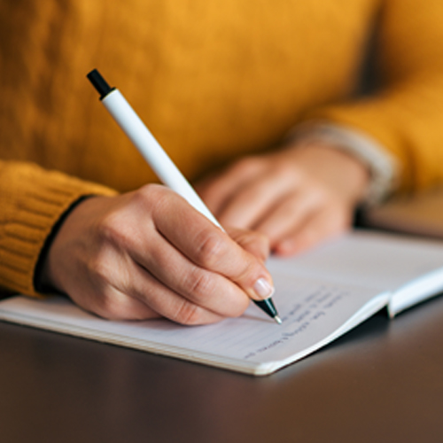 Person writing in a notebook.