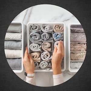 clothing folded neatly into three separate drawer organizers