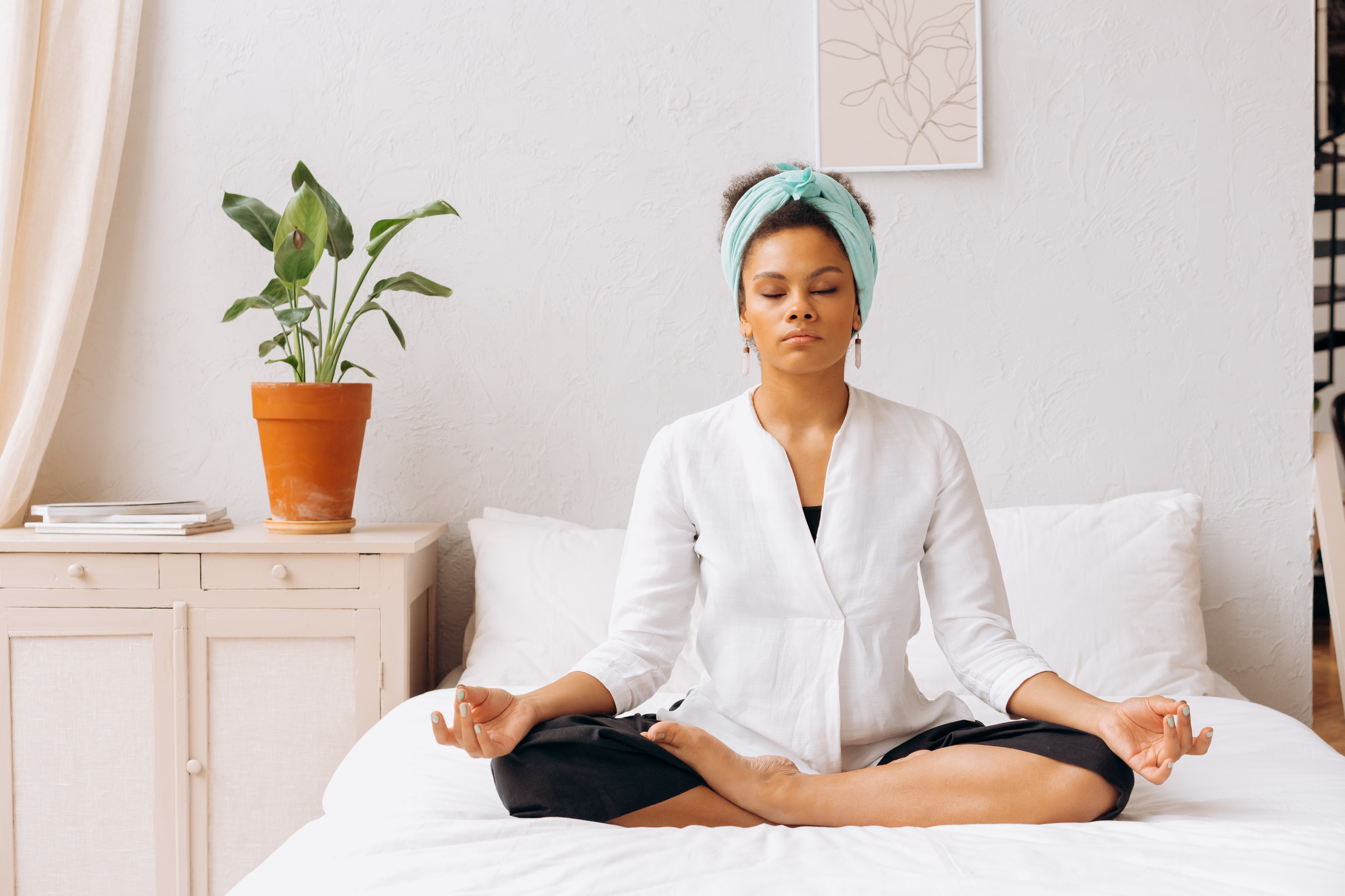 Young woman meditating on bed