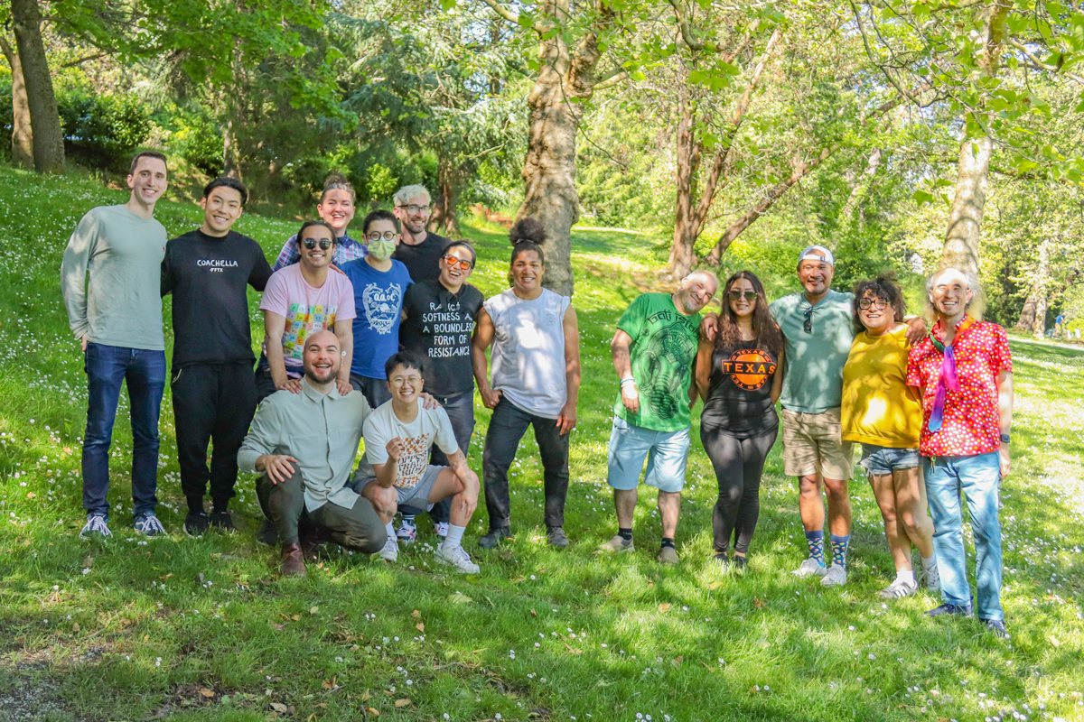 A group photo in the grass in a park of staff members who work at Seattle&#39;s LGBTQ+ Center. 