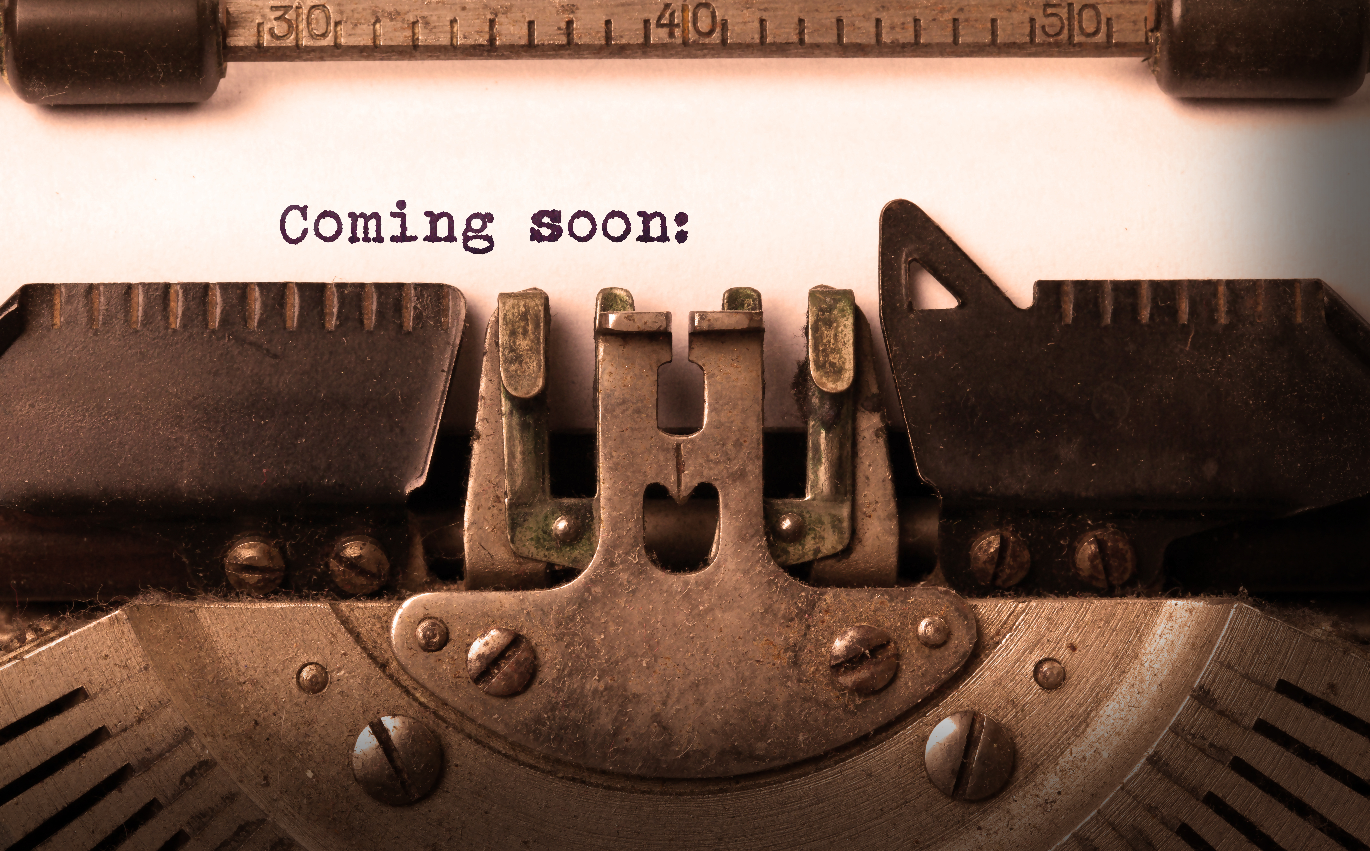 A typewriter writing out coming soon!