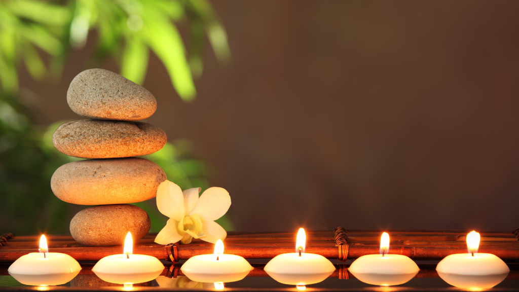 Stack of rocks on bamboo with floating candles