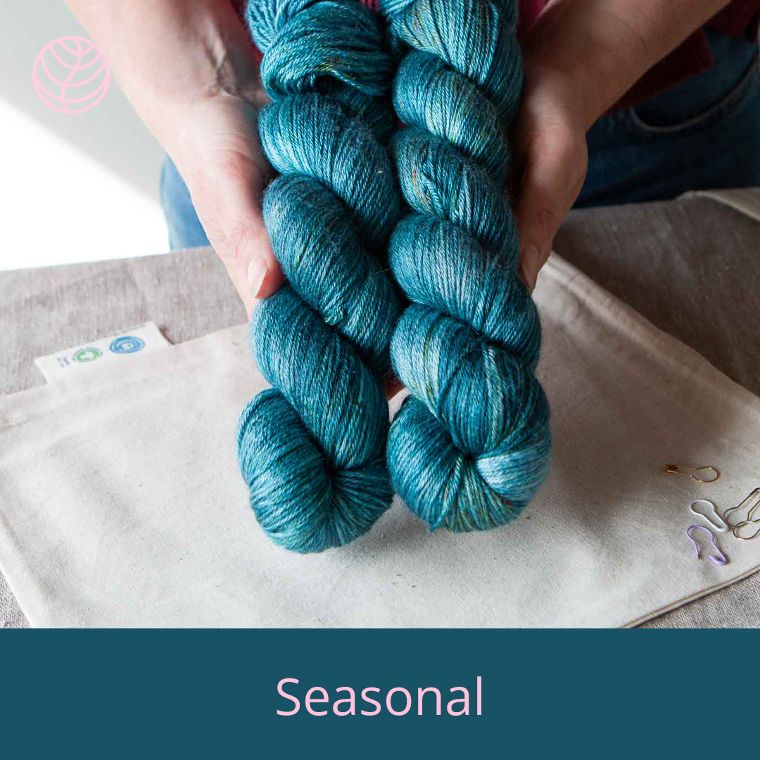 Hands holding two skeins of bright blue yarn.
