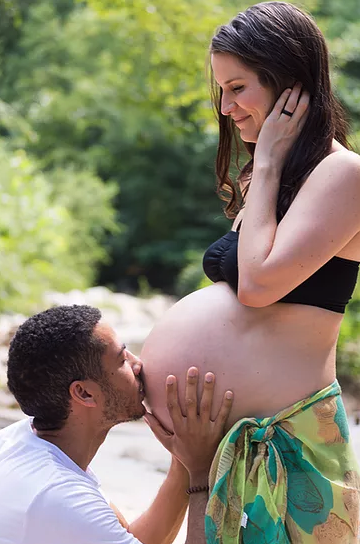 Sarah Bivens and Matthew Bivens kissing her pregnant belly