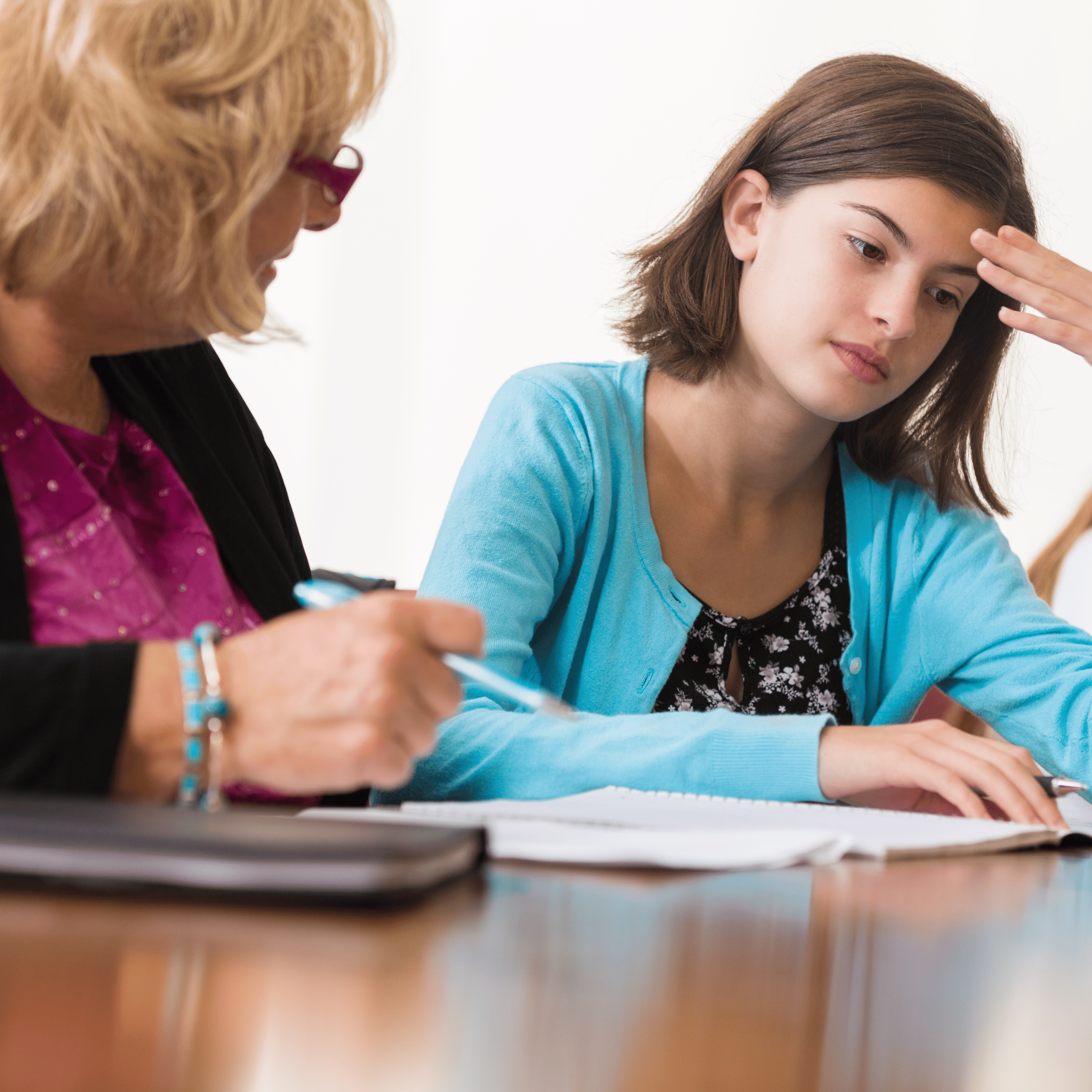 teacher sitting with perplexed student