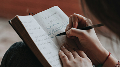 A young woman writing in a notebook