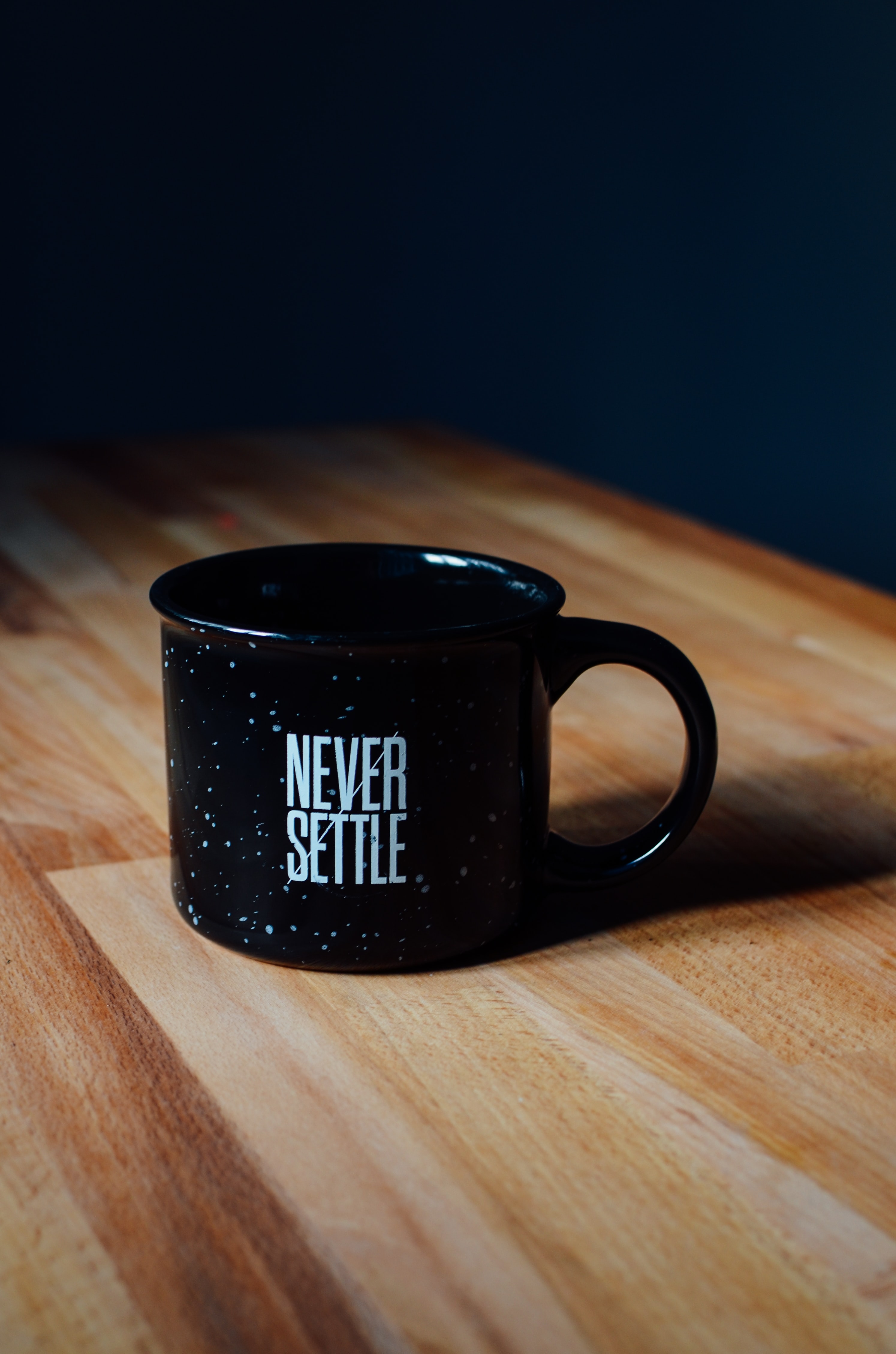 &quot;Never Settle&quot; typed on a coffee mug
