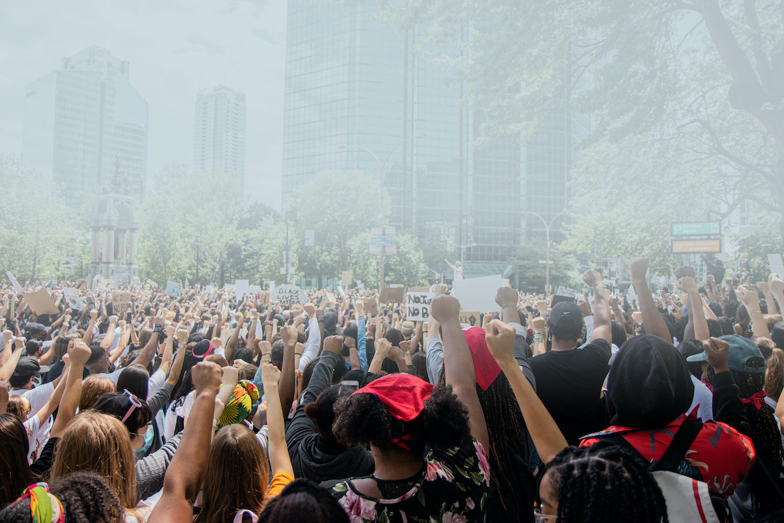 Hundreds of people raise fists at a Black Lives Matter demonstration