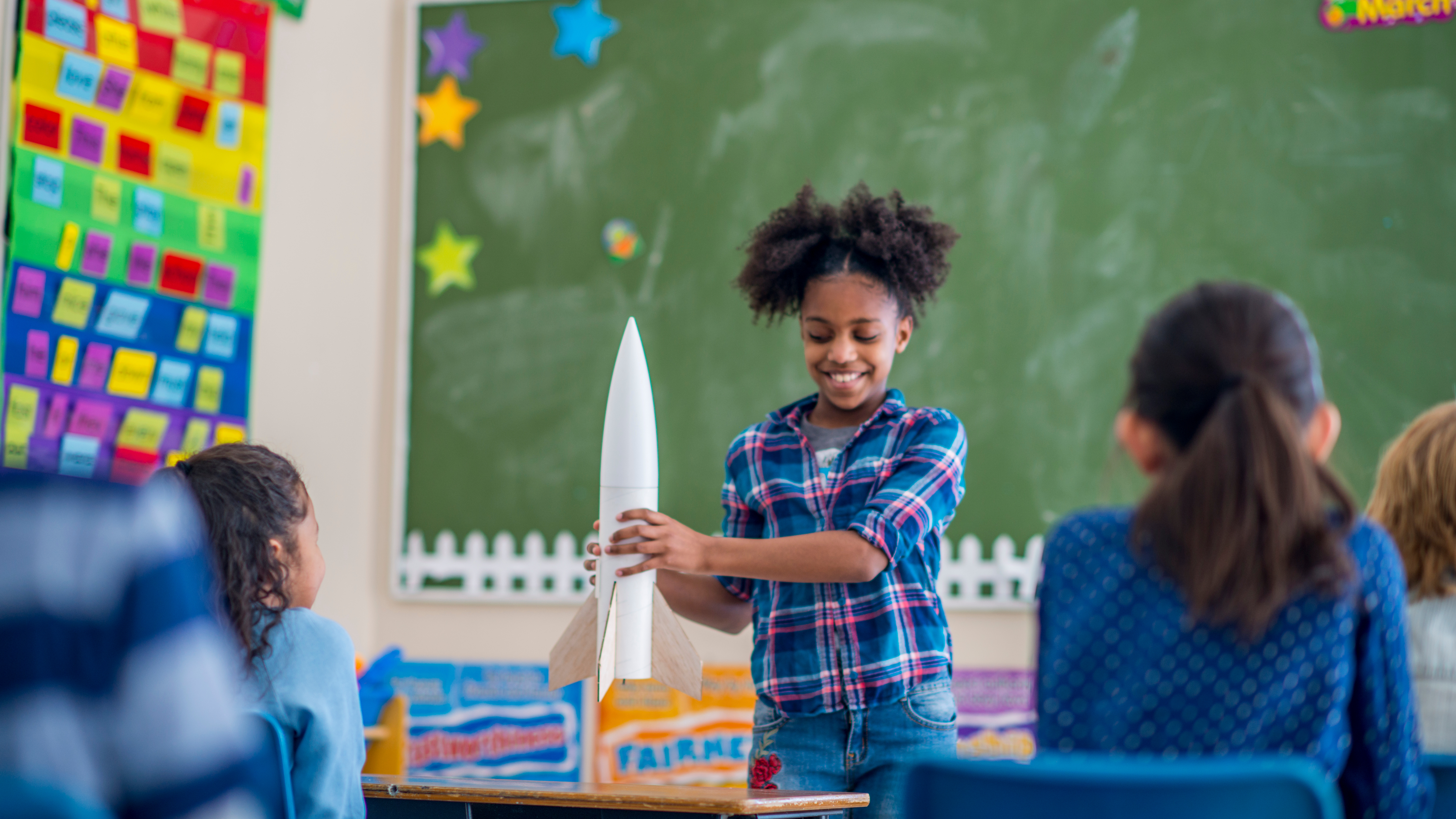 student holding model rocket