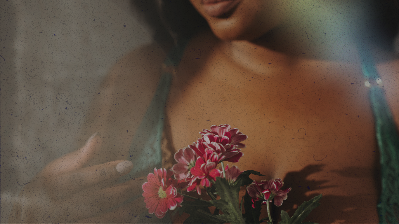 woman holding pink flowers and staring down at the flower