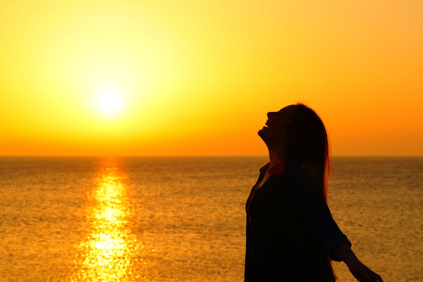 woman standing in ocean sunset