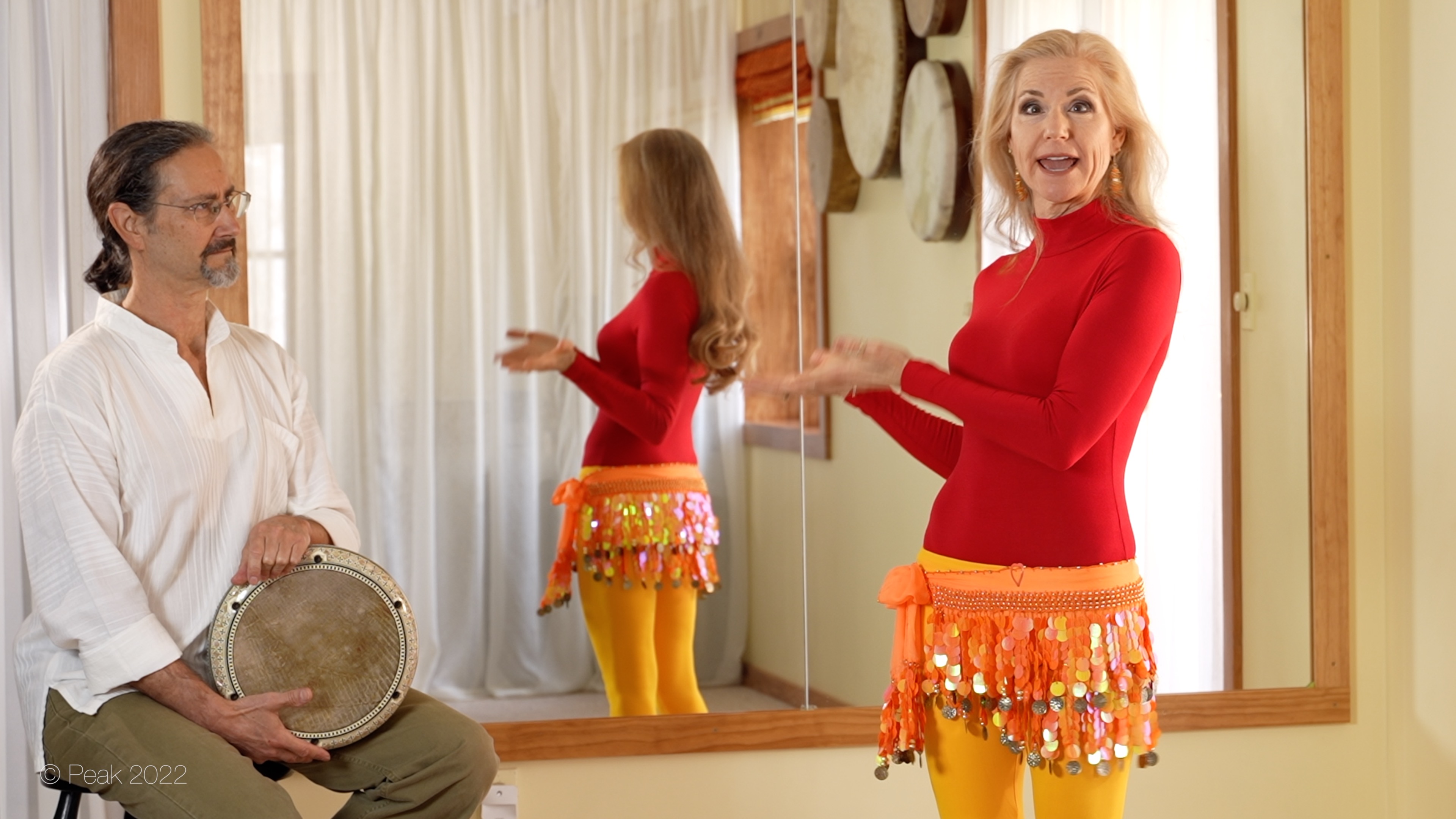 Belly dancer Jensuya gesturing towards drummer Robert Peak in studio