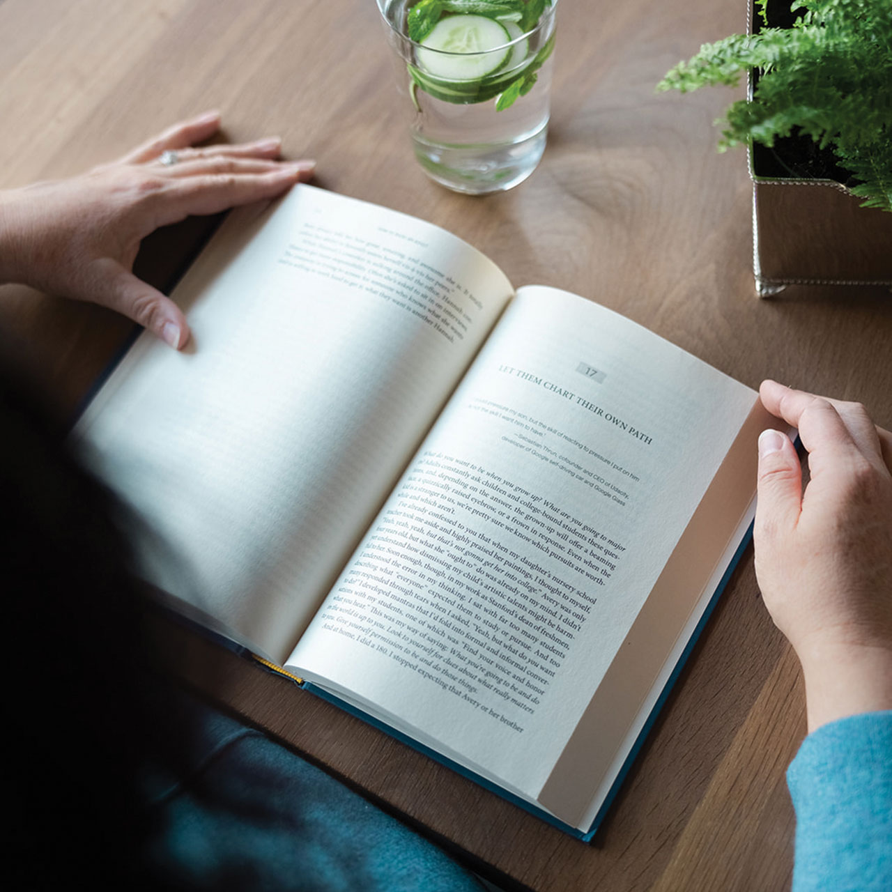 Michelle reading a book with a glass of water.