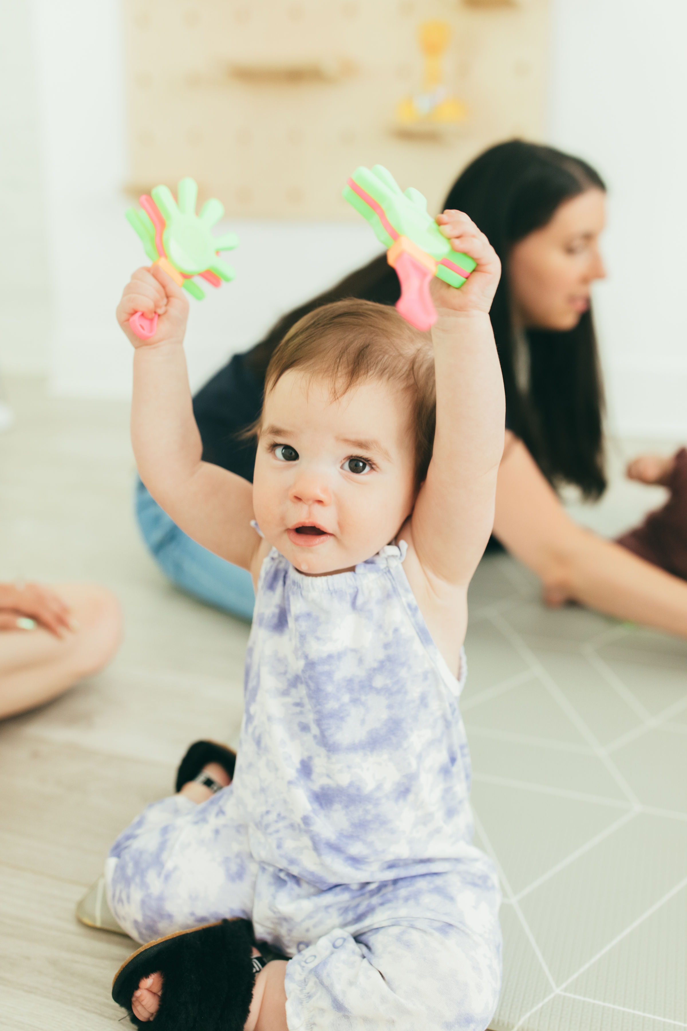 A baby holds up our hello hands toy