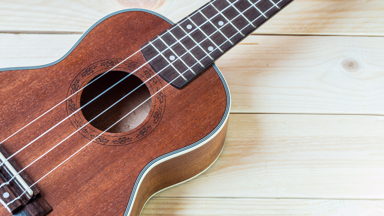 Brown ukulele close up over top of wood