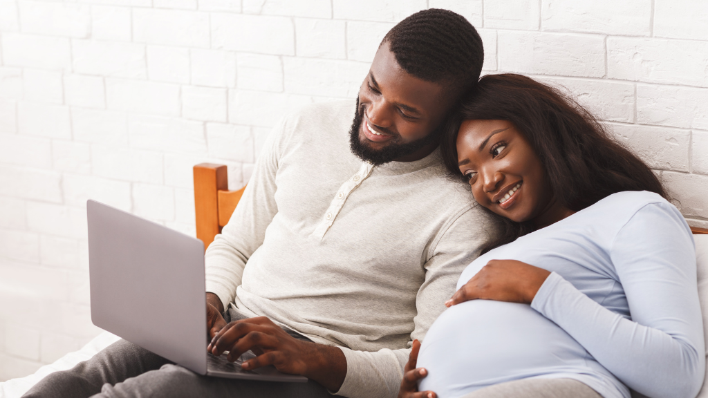 couple snuggled on the couch with laptop smiling