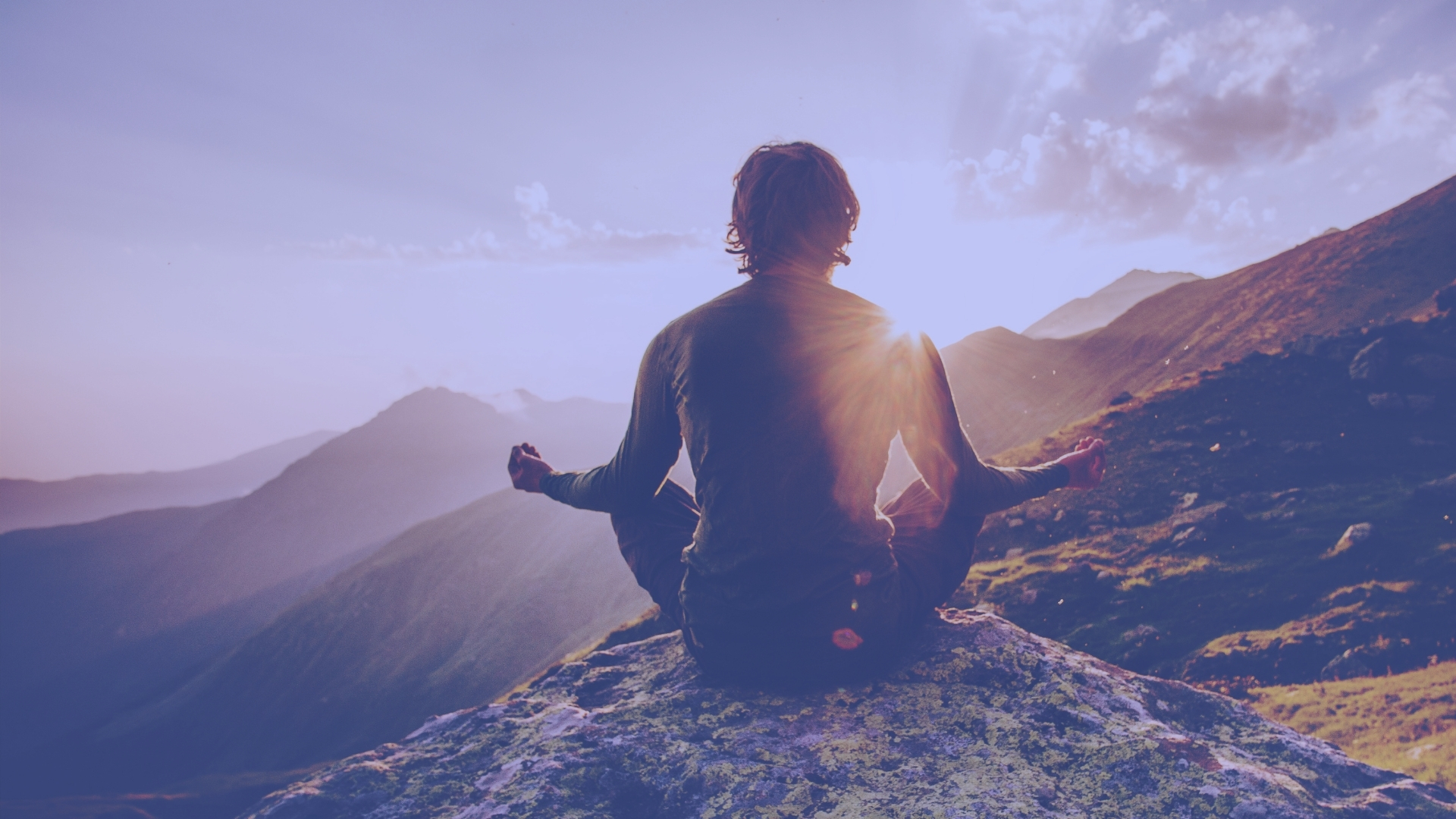 Person meditating in beautiful mountain landscape.