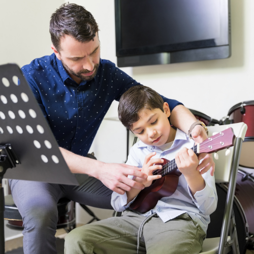 teacher and boy ukulele lesson