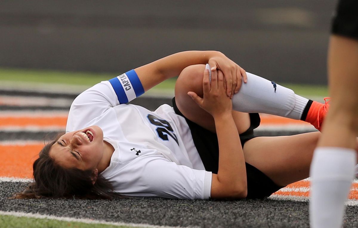 Soccer player in pain due to knee and ACL injury.